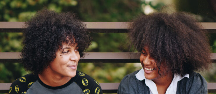 Two women of color laughing together. Photo by Eye for Ebony on Unsplash